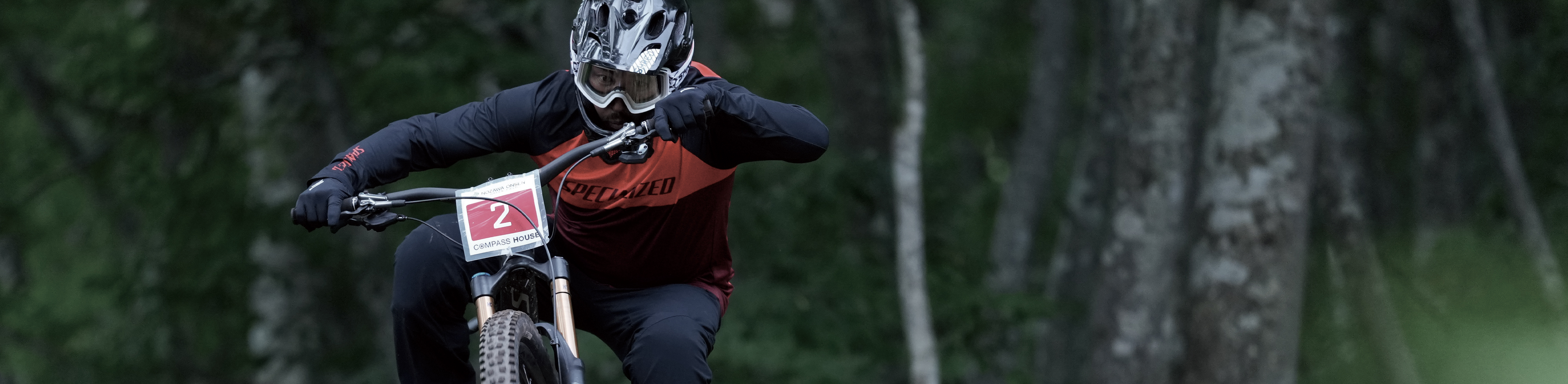 Пример изображения мотоциклиста в фокусе, находящегося в движении на соревновании, на фоне леса с эффектом боке