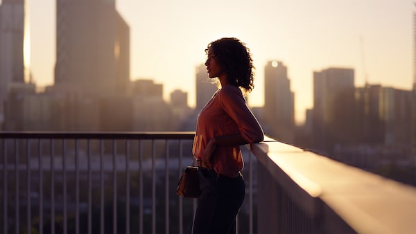 Портрет женщины, силуэт которой отображен на фоне городского пейзажа