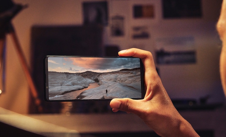 Человек держит Xperia 1 III, на дисплее которого отображается зимний пейзаж