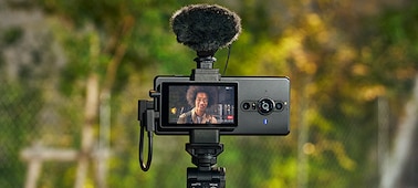 Монитор Vlog Monitor, закрепленный на смартфоне, к которому подключен внешний микрофон и рукоятка для съемки с Bluetooth