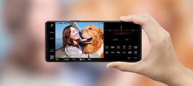 Человек держит Xperia 1 III, на экране которого изображена женщина в обнимку с собакой