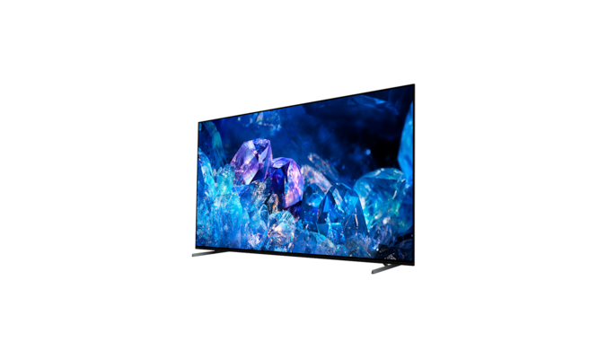 Телевизор BRAVIA A80K с подставкой и изображением синих и фиолетовых кристаллов на экране, вид с угла сзади