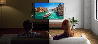Пара на диване смотрит телевизор, на экране которого — изображение лодки на реке, демонстрирующее преимущества датчика освещенности