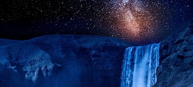 Крупный план ночного водопада со звездами, освещенными галактикой в небе