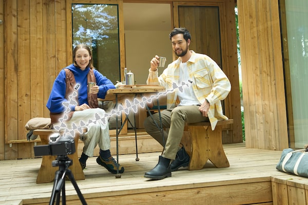 Изображение, на котором двое мужчин и женщин снимают на камеру с микрофоном.