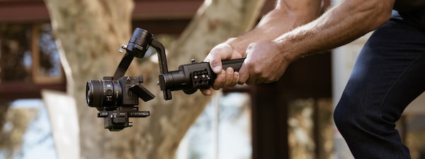 Фотография мужчины, снимающего видео с помощью камеры, установленной на стабилизаторе