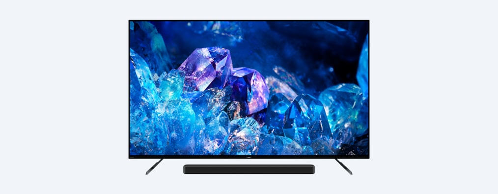 Телевизор BRAVIA A80K на подставке с саундбаром и изображением голубых и фиолетовых кристаллов на экране, вид спереди