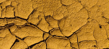 Изображение сухой поверхности земли коричневого цвета с трещинами