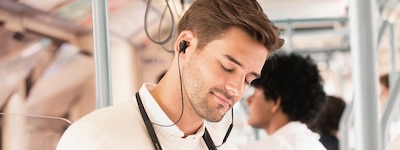 Изображение мужчины, который слушает музыку в наушниках WI-1000XM2 в общественном транспорте