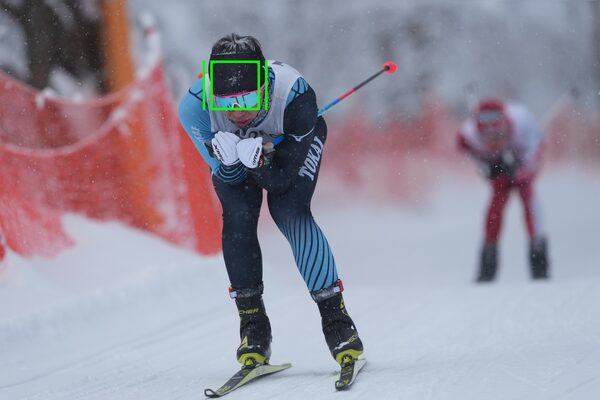 Изображение движущегося лыжника с меткой индикатора слежения, наложенной на изображение головы лыжника