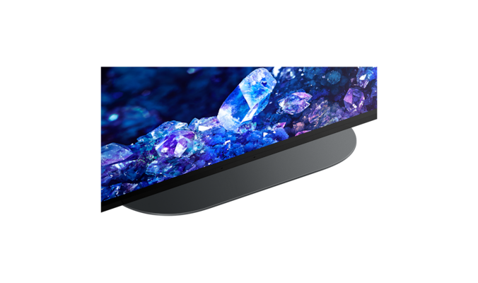 Крупный план на подставке телевизора с изображением синих и фиолетовых кристаллов на экране