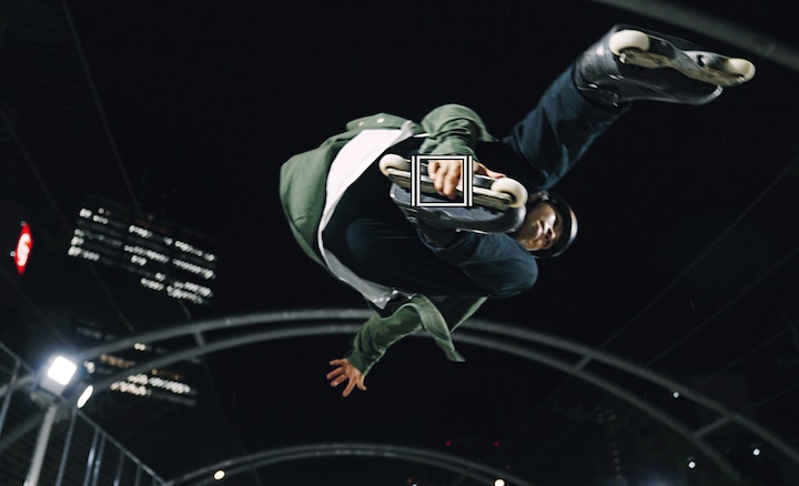 Человек на роликах в воздухе; на изображении имеется зеленый квадрат системы автофокусировки