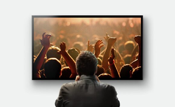Человек за просмотром телевизора Sony с экраном 216 см/85 дюймов