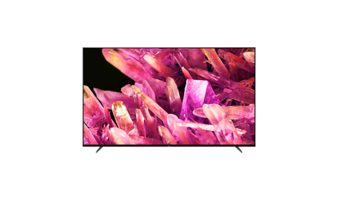 Телевизор BRAVIA X90K на подставке с изображением розовых кристаллов на экране, вид спереди