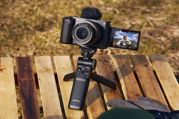 Изображение камеры на столе с прикрепленной рукояткой, используемой в качестве штатива
