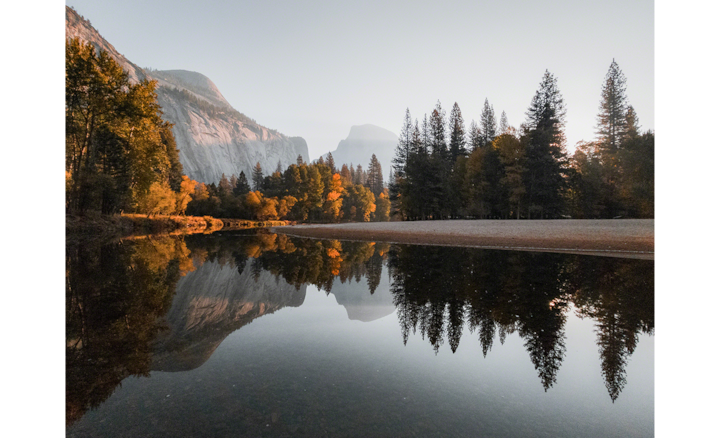 Отражение деревьев и гор в озере.
