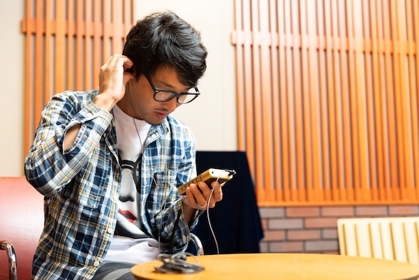 Рё Омура слушает музыку с плеера Sony Walkman