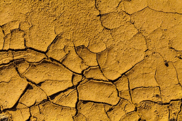 Изображение сухой поверхности земли коричневого цвета с трещинами