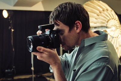 Мужчина фотографирует в студии камерой Sony Alpha