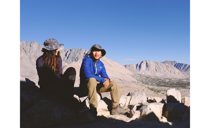 Мужчина и женщина сидят на скалах на фоне горного пейзажа