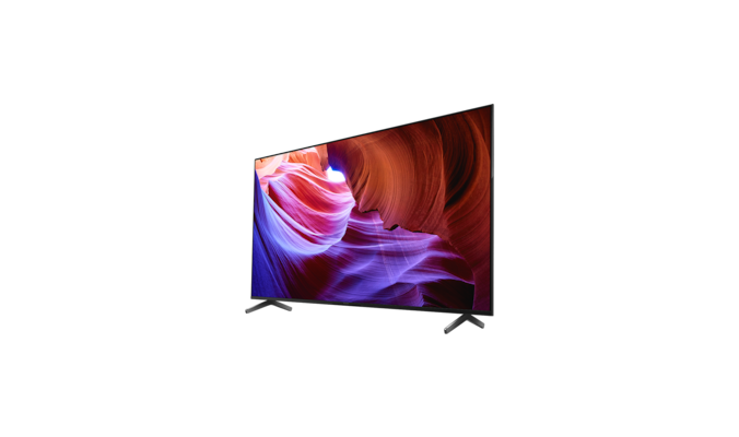 Телевизор BRAVIA X85K с изображением фиолетовых и оранжевых объектов на экране, вид под углом