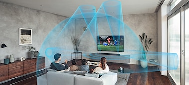 Семья на диване в гостиной смотрит стоящий на мраморной полке телевизор с саундбаром HT-A7000. Улучшение звучания включено
