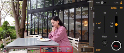 Снимок экрана Xperia, демонстрирующий интерфейс Videography Pro, а также изображение женщины, сидящей за столиком возле здания