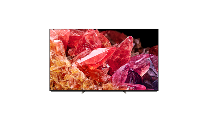 Телевизор BRAVIA X95K на подставке с изображением красных и оранжевых кристаллов на экране, вид спереди