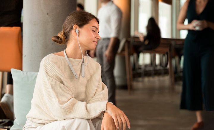 Изображение женщины, которая слушает аудио высокого разрешения в наушниках WI-1000XM2