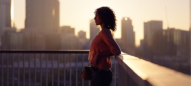 Портрет женщины, силуэт которой отображен на фоне городского пейзажа